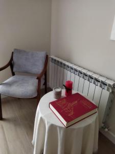 un libro rojo sentado en una mesa con una silla en Apartamento El Nido en La Guardia
