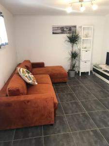 salon z brązową kanapą w pokoju w obiekcie Maison avec piscine au calme w mieście Puygiron +2 zdjęcia