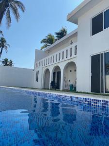 een huis met een zwembad voor een gebouw bij Casa Maravatío M R in Playa Azul