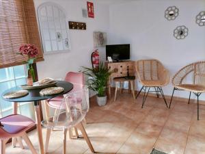 a living room with tables and chairs and a television at El Somadero B in Fuencaliente de la Palma