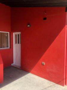 czerwony pokój z białymi drzwiami i czerwoną ścianą w obiekcie Vientos Del Sur w mieście Río Gallegos