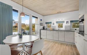eine Küche mit weißen Schränken sowie einem Tisch und Stühlen in der Unterkunft Cozy Home In Ebeltoft With Indoor Swimming Pool in Ebeltoft