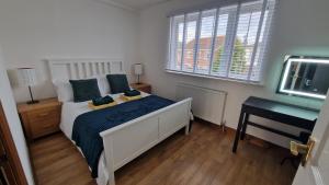 a bedroom with a bed and a desk and a television at 3-Bedroom Family Holiday Home in Skegness