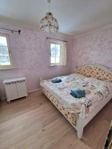 1 dormitorio con cama y pared de color rosa en Apartmán provence Bystrá Chopok 2, en Bystrá