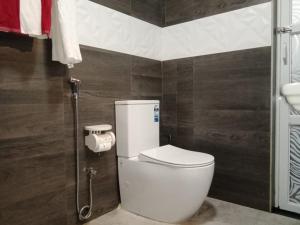 uma casa de banho com um WC branco num quarto em Friendly home stay em Etagama