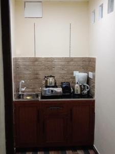 um balcão de cozinha com duas panelas e um lavatório em Friendly home stay em Etagama