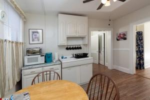 - une cuisine avec des placards blancs, une table et des chaises dans l'établissement The Bushnell Suite C2, à Hartford