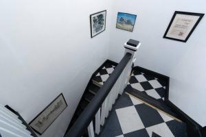 un escalier avec un sol en damier et des photos sur le mur dans l'établissement The Bushnell Suite C2, à Hartford