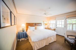 a bedroom with a large white bed and a window at White Elephant Hotel in Nantucket