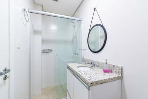 a bathroom with a shower and a sink and a mirror at 1 quadra da Catedral - @stayhousetemporada in Canela +19 photos