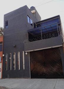 un edificio negro con una gran puerta de garaje en Alojamiento GAMA en Ciudad de México