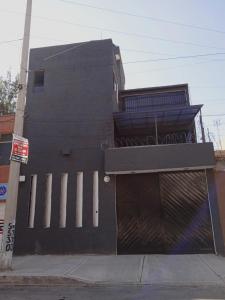 un edificio negro con una puerta y un garaje en Alojamiento GAMA en Ciudad de México