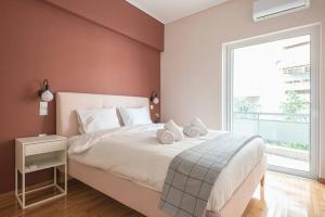 Schlafzimmer mit einem großen weißen Bett und einem Fenster in der Unterkunft Pale Orb Properties (2) in Athen