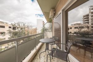 einen Balkon mit einem Tisch und Stühlen in der Unterkunft Pale Orb Properties (2) in Athen