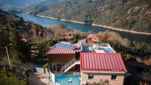 una vista aérea de una casa con paneles solares en un río en Casa do Lagar, en Gerês