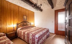 a bedroom with a bed and a wooden wall at Maison nonna Tilde - Valsusa in Mattie