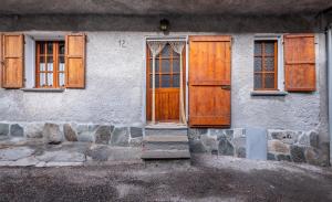 a building with wooden doors and windows on it at Maison nonna Tilde - Valsusa in Mattie