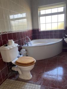 een badkamer met een bad, een toilet en een wastafel bij Lake Big, Five Bedroom Holiday Home Rosslare Strand, County Wexford in Mervyn