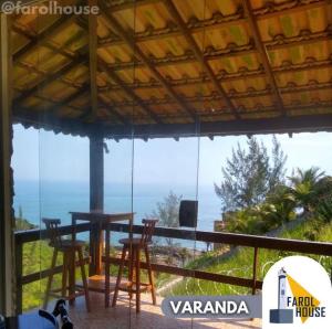 d'une table et de chaises sur un balcon avec vue sur l'océan. dans l'établissement Farol House, à Maricá