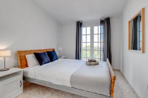 a white bedroom with a large bed and a window at Bonita Casa Nina con Jacuzzi By Paramount Holidays in Playa de San Juan