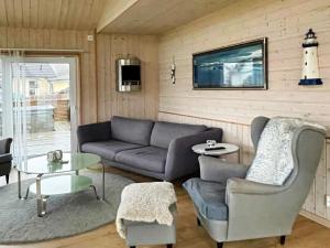 uma sala de estar com um sofá e cadeiras e uma televisão em Holiday home STORAHÖGA III em Stora Höga