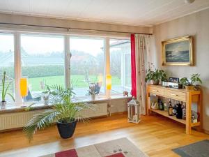 uma sala de estar com uma grande janela e plantas em Holiday home STORAHÖGA III em Stora Höga