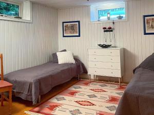 a bedroom with two beds and a dresser and a rug at Holiday home STORAHÖGA III in Stora Höga