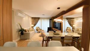 a dining room and living room with a table and chairs at Rosa Edifício Vivere Canela in Canela