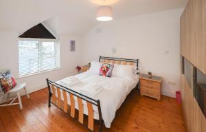 a bedroom with a bed and a wooden floor at Two bedroom townhouse in the heart of Dungarvan in Dungarvan