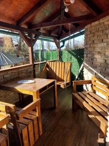 - un patio avec une table en bois et des bancs dans un pavillon dans l'établissement Filigran, à Palić