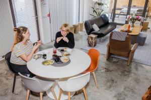dos mujeres sentadas en una mesa comiendo comida en Viktoria Guesthouse, en Westerlo