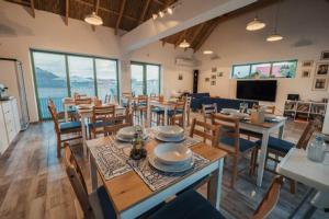 un comedor con mesas y sillas en una habitación con ventanas en Pensiunea Delta Drill, en Sfântu Gheorghe