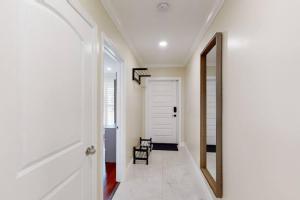 einen Flur mit einer weißen Tür und einem Spiegel in der Unterkunft Premium Luxury 5BR Villa near Hollywood Beach in Hollywood