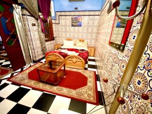 Cette petite chambre comprend 2 lits et un tapis rouge. dans l'établissement Riad Fattouma Kasba, à Marrakech