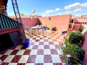 eine Terrasse mit einem Tisch und einem karierten Boden in der Unterkunft Riad Fattouma Kasba in Marrakesch