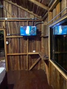 Habitación con TV en la pared y ventana en Finca Avellanas en Playa Avellana
