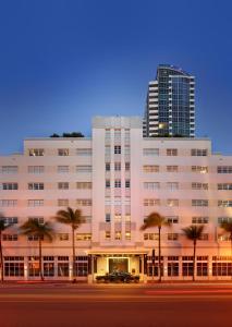 a large white building with palm trees in front of it at The Setai, Miami Beach in Miami Beach