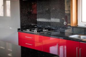 uma cozinha com armários vermelhos e um balcão preto em Casa do Lagar no Gerês