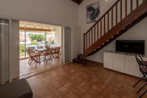 a living room with a staircase and a table and chairs at La Rose du Marisol in Le Gosier