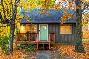 a small house with a porch and a green door at Love Ridge Mountain Lodging in Lyndhurst