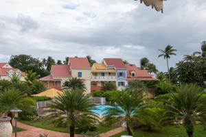 a resort with a swimming pool and palm trees at La Rose du Marisol in Le Gosier