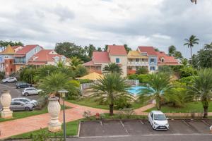 a row of houses with cars parked in a parking lot at La Rose du Marisol in Le Gosier