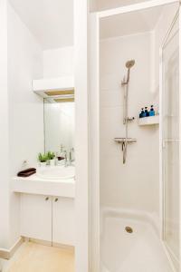 a white bathroom with a shower and a sink at Le Cosy - Free Parking - 2 min métro - 5 min Paris in Charenton-le-Pont
