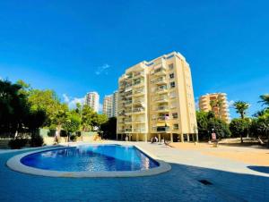a swimming pool in front of a tall building at Casa Bendita - LUXURY APARTMENT BENIDORM in Benidorm