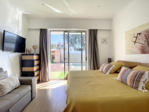 a bedroom with a bed and a couch and a television at Bed and Breakfast Summer Cascade Pequeno almoço incluido in Alvor