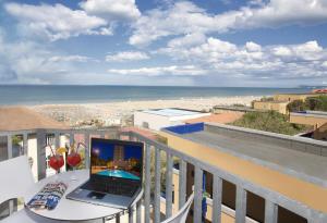 里米尼的住宿－珍寶酒店，海滩阳台桌子上的笔记本电脑
