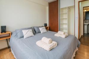 um quarto com uma cama grande e toalhas em Belgrano R em Ushuaia
