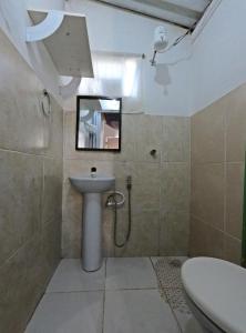 een badkamer met een wastafel, een toilet en een spiegel bij Hospedagem Alternativa in Alto Paraíso de Goiás