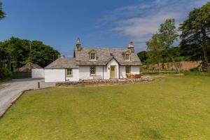 una gran casa blanca con un gran patio en Home Farm Cottage, en Stranraer