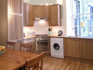 cocina con lavadora y mesa en 1 Bellevue Terrace, en Edimburgo